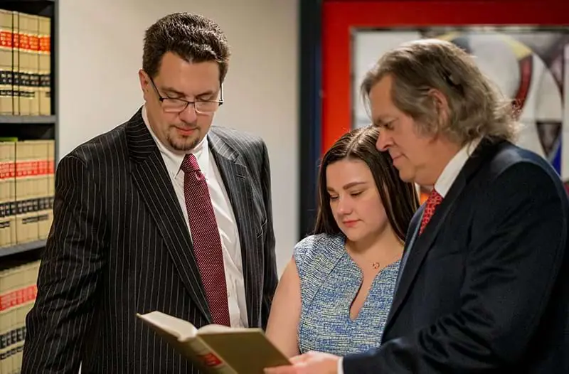 Johnston, Moore & Weston attorneys reviewing a case file